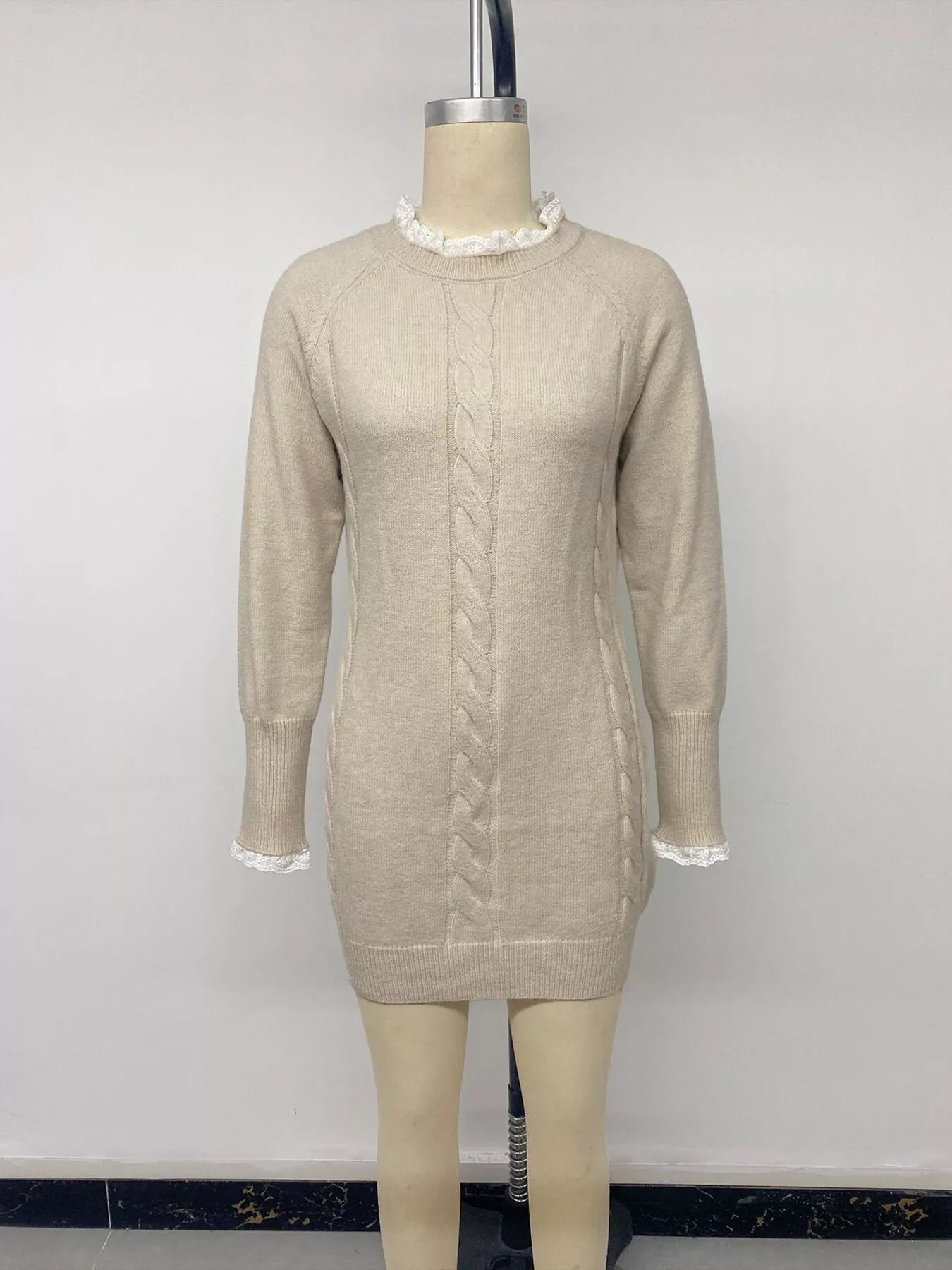 Beige cable knit sweater dress with lace collar and cuffs displayed on a mannequin, front view