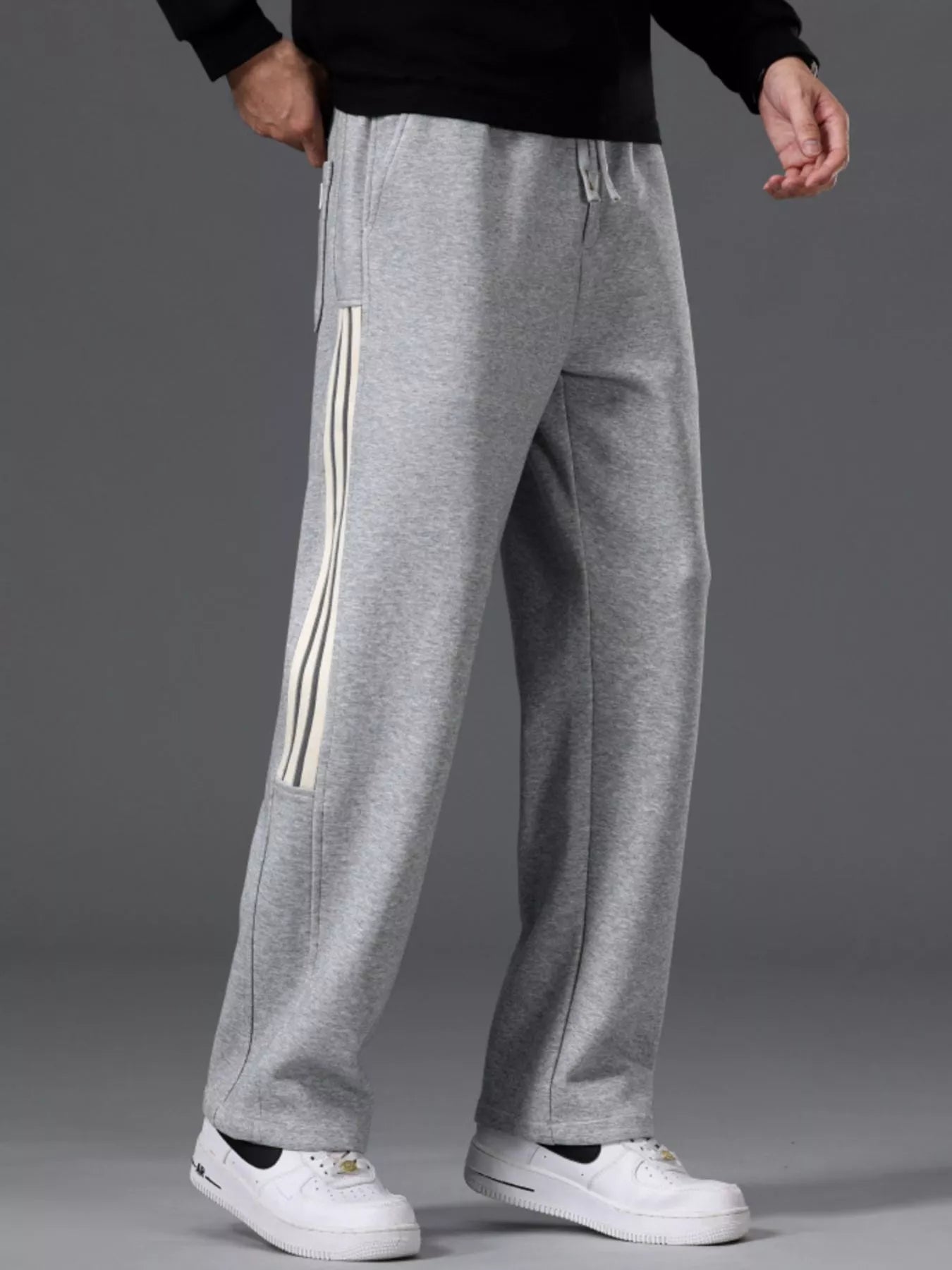 Men's gray striped wide-leg pants with a drawstring waist and pockets.