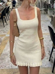 Front view of a cream ribbed knit square neck dress with wide straps and ruffled hem.