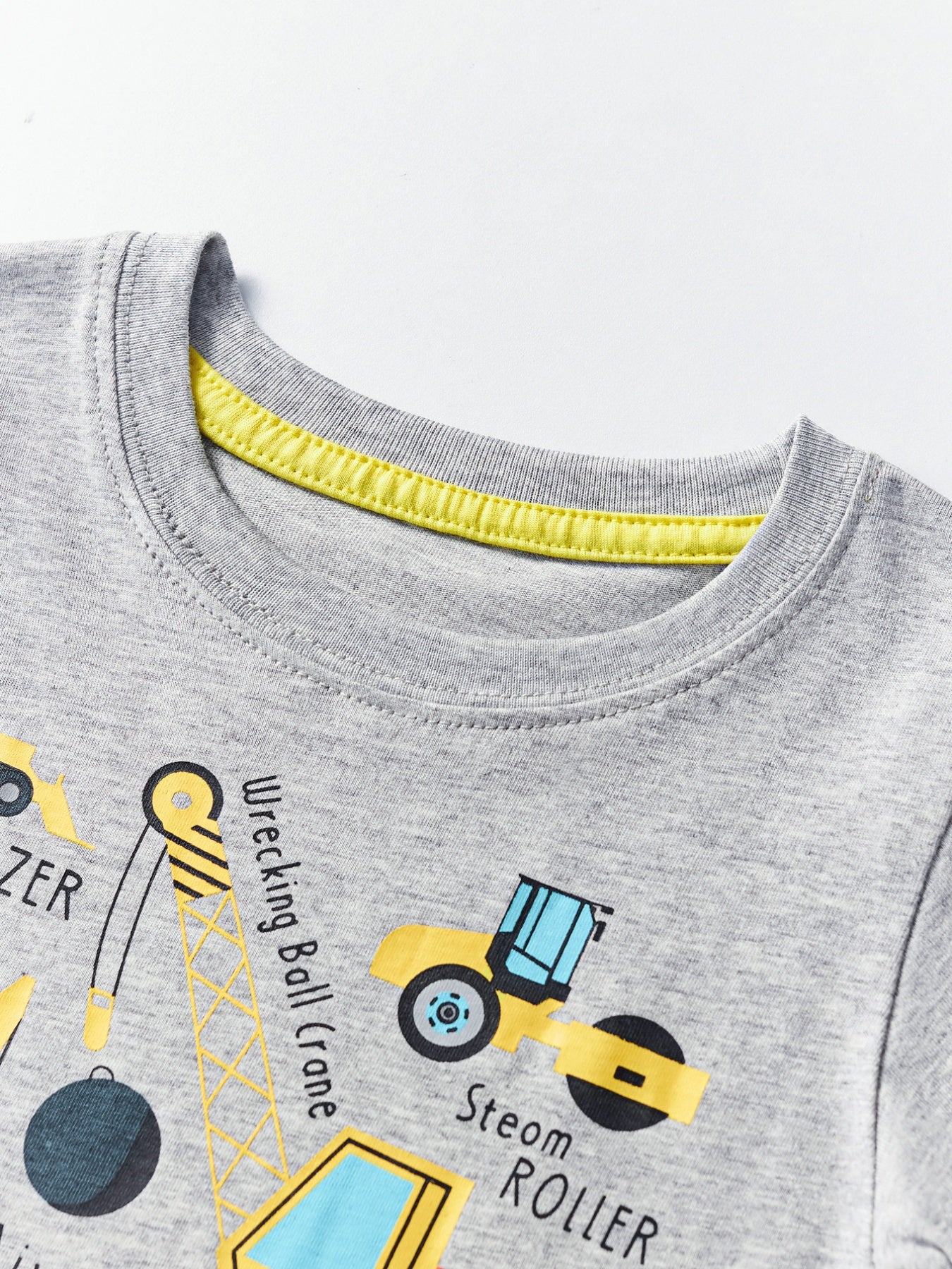 Close-up of the light gray crew neckline with yellow inner trim on a children's construction vehicle T-shirt