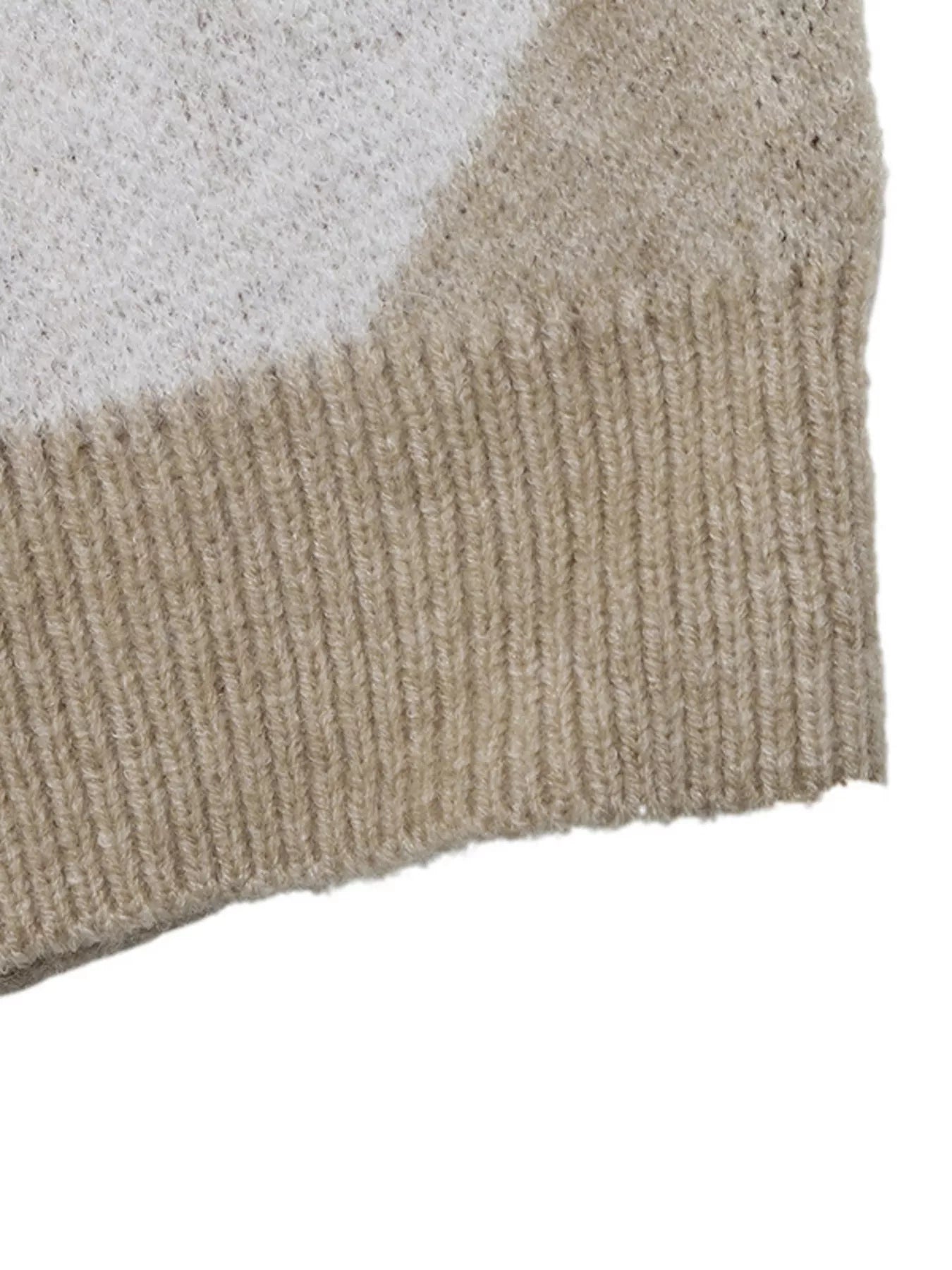 Close-up of the beige ribbed hem on the argyle polo sweater