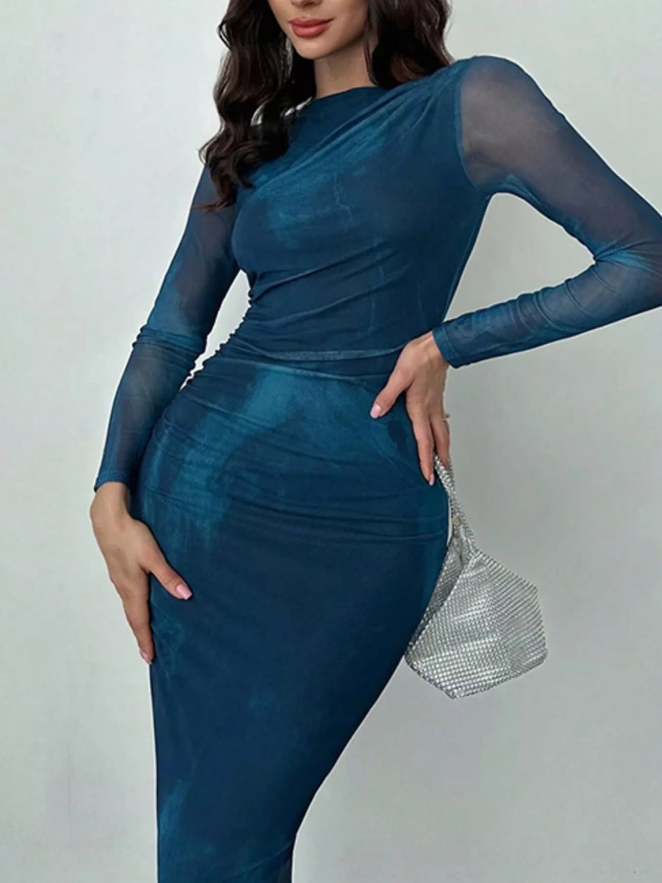 Blue tie dye long sleeve bodycon maxi dress worn front facing with a hand on the hip
