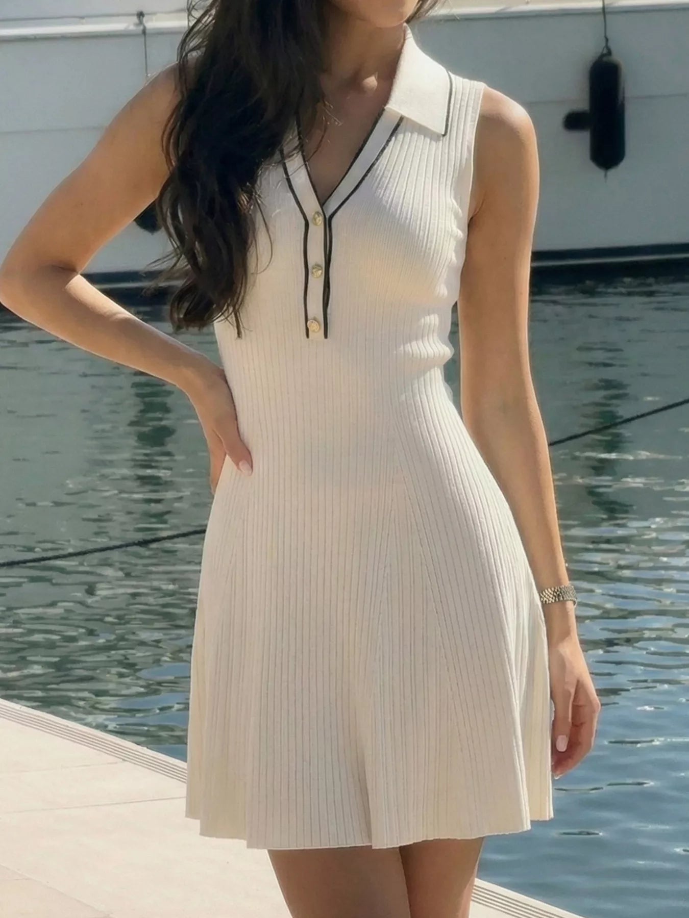 Side angle on-model front view of the cream ribbed polo dress with black trim
