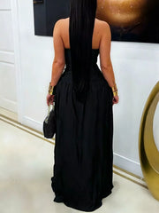 Back view of black halter maxi dress with flowing skirt worn indoors