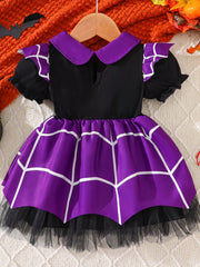 Purple and black dress featuring a white geometric print, puff sleeves, contrasting collar, and black tulle hem.
