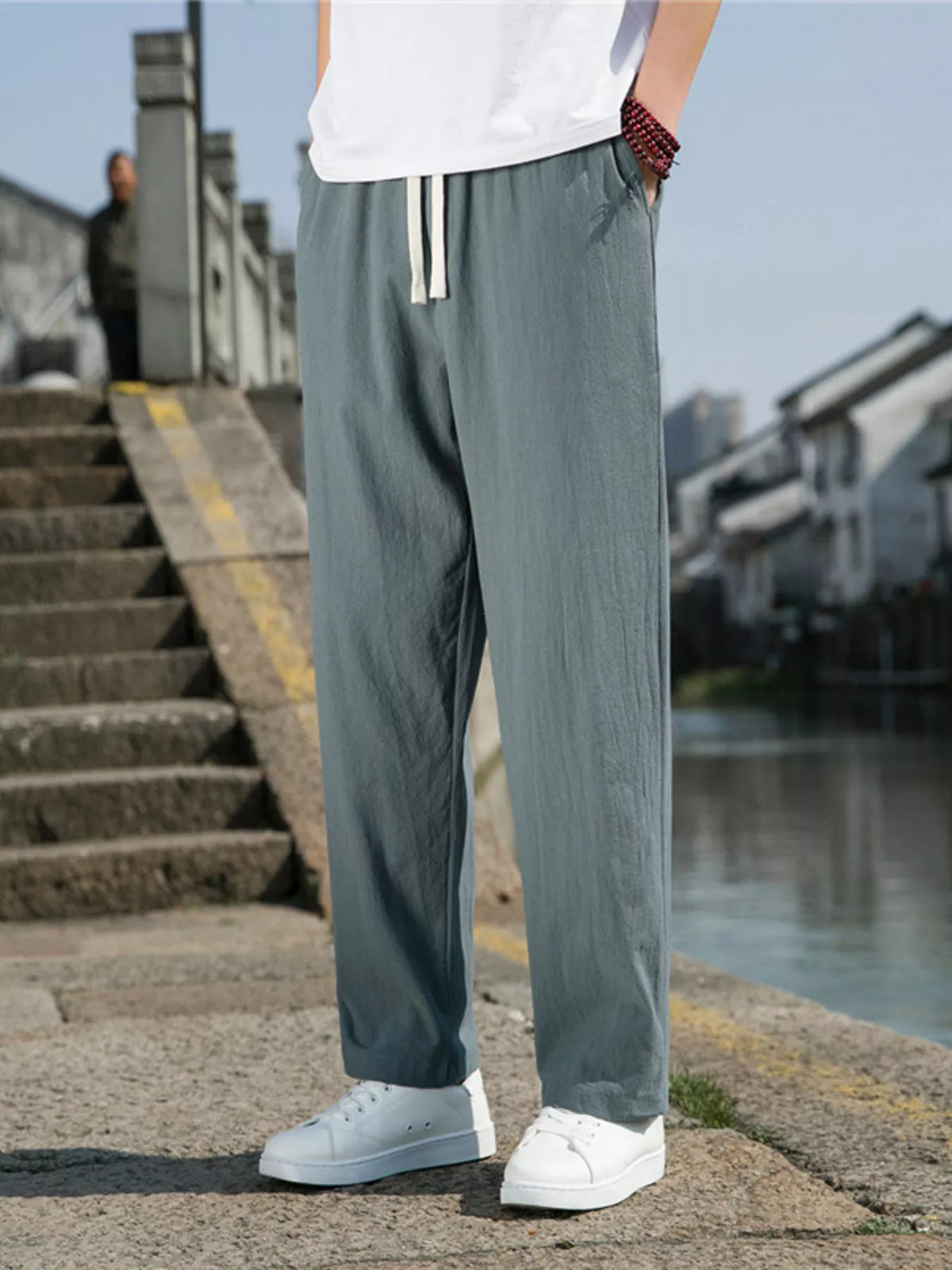 Men's green loose-fit casual pants with a drawstring waist and pockets.