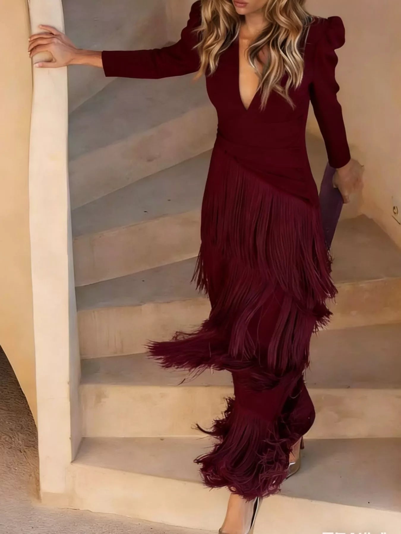 Full length view of a burgundy fringed maxi dress worn walking down outdoor stairs