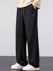 Men's black loose fit casual pants with a drawstring waist and pockets.