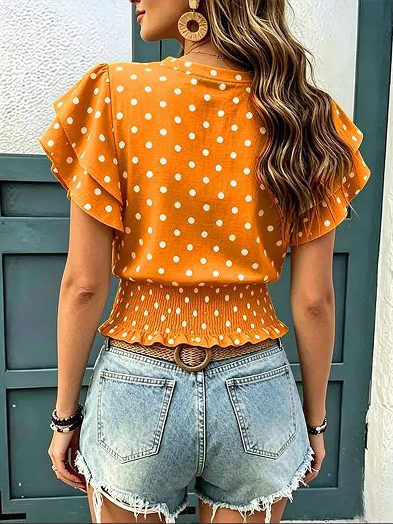 Back view of orange polka dot blouse with ruffle sleeves