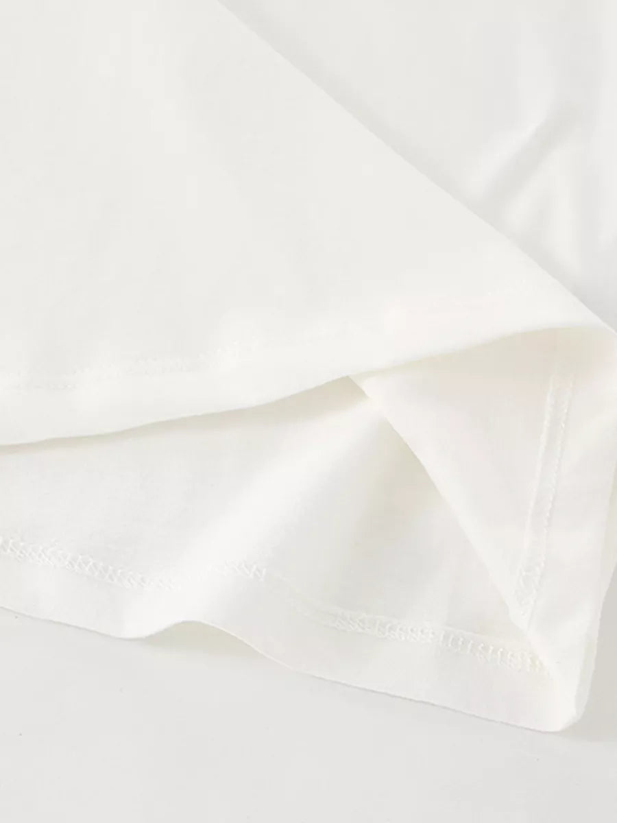 Detail view of the folded hem and stitching on a children's plain white short sleeve tee