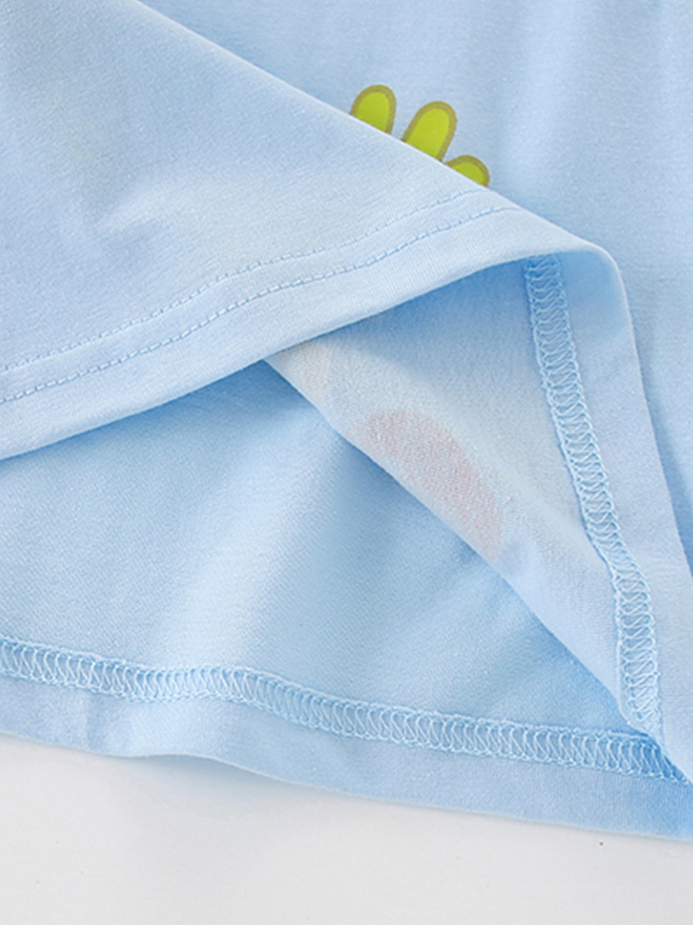 Close-up detail of the light blue hem stitching and inner seam on children's farm T-shirt