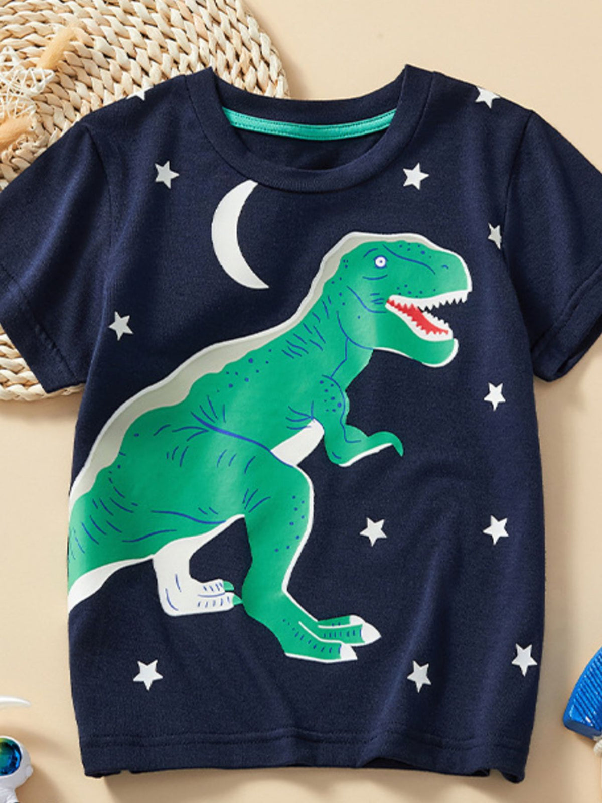 Flat lay front view of children's dark navy t-shirt with large green dinosaur and stars