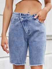 Women's asymmetrical denim shorts with raw hems and pockets.