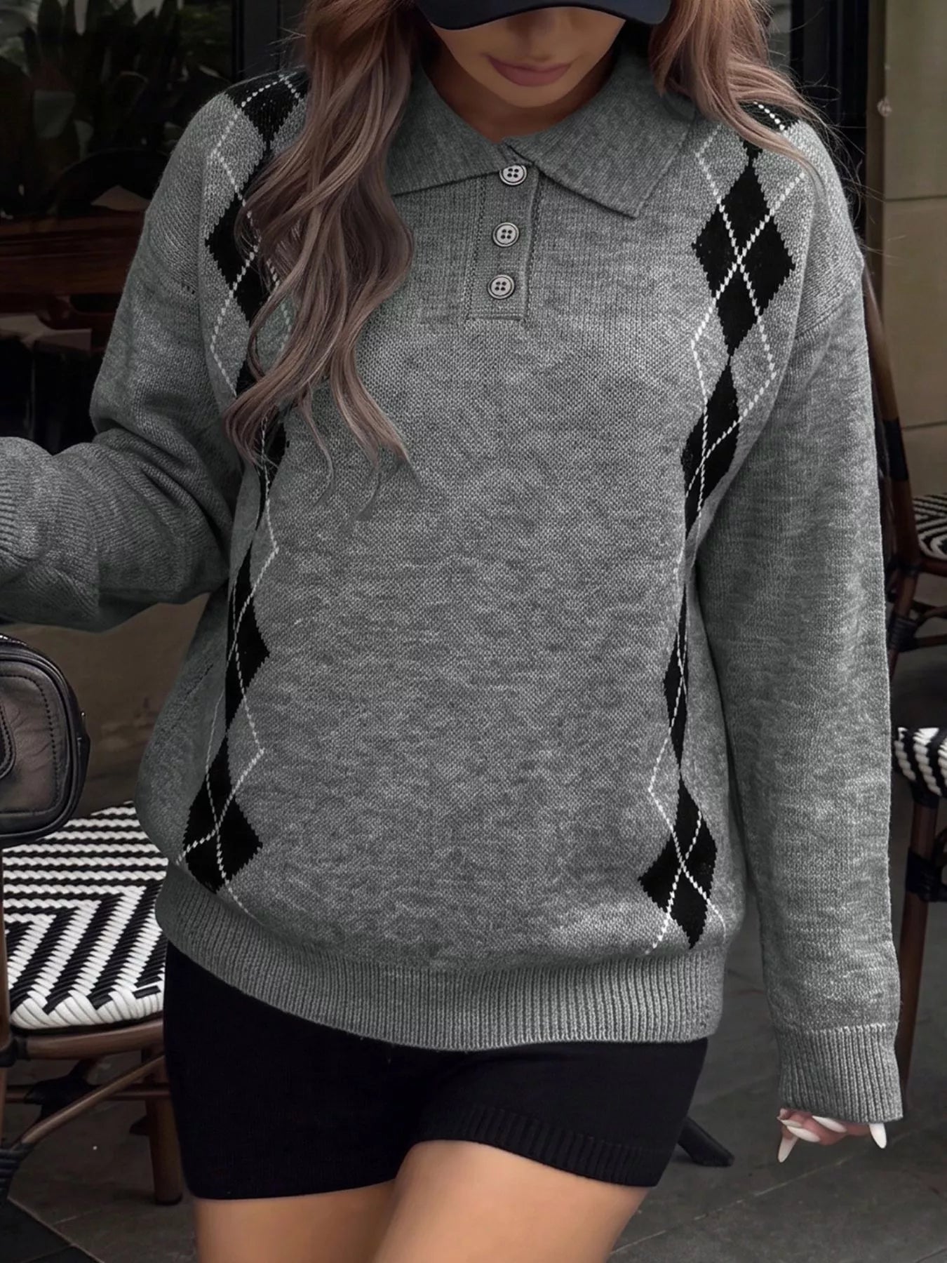Front view of a gray polo sweater with black argyle side panels and three buttons