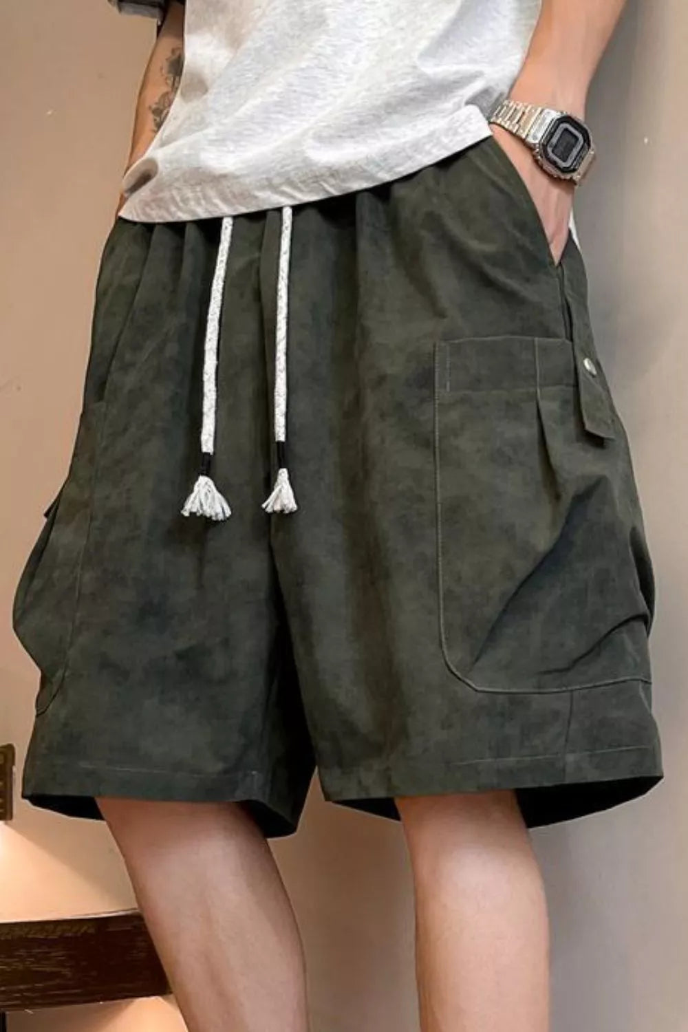 Men's military green drawstring shorts with pockets and lightweight fabric.
