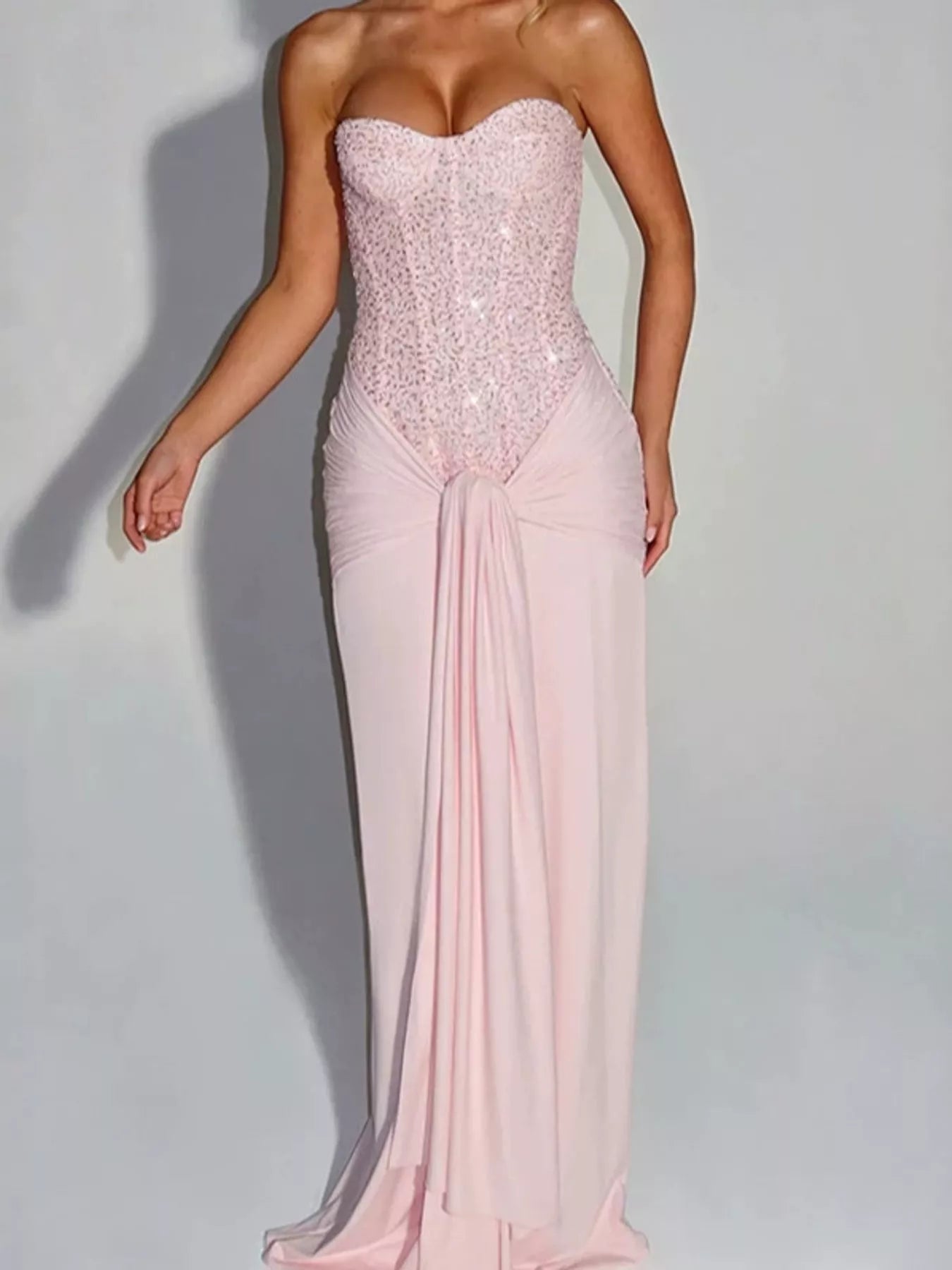 Pink strapless sequin corset maxi dress with draped waist on model, studio front view