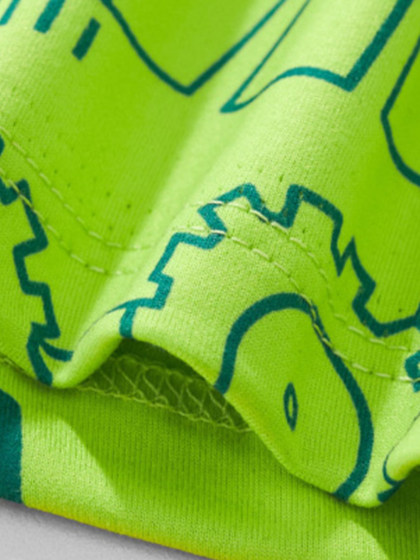 Close-up of the fabric texture and seam stitching on the children's neon green t-shirt
