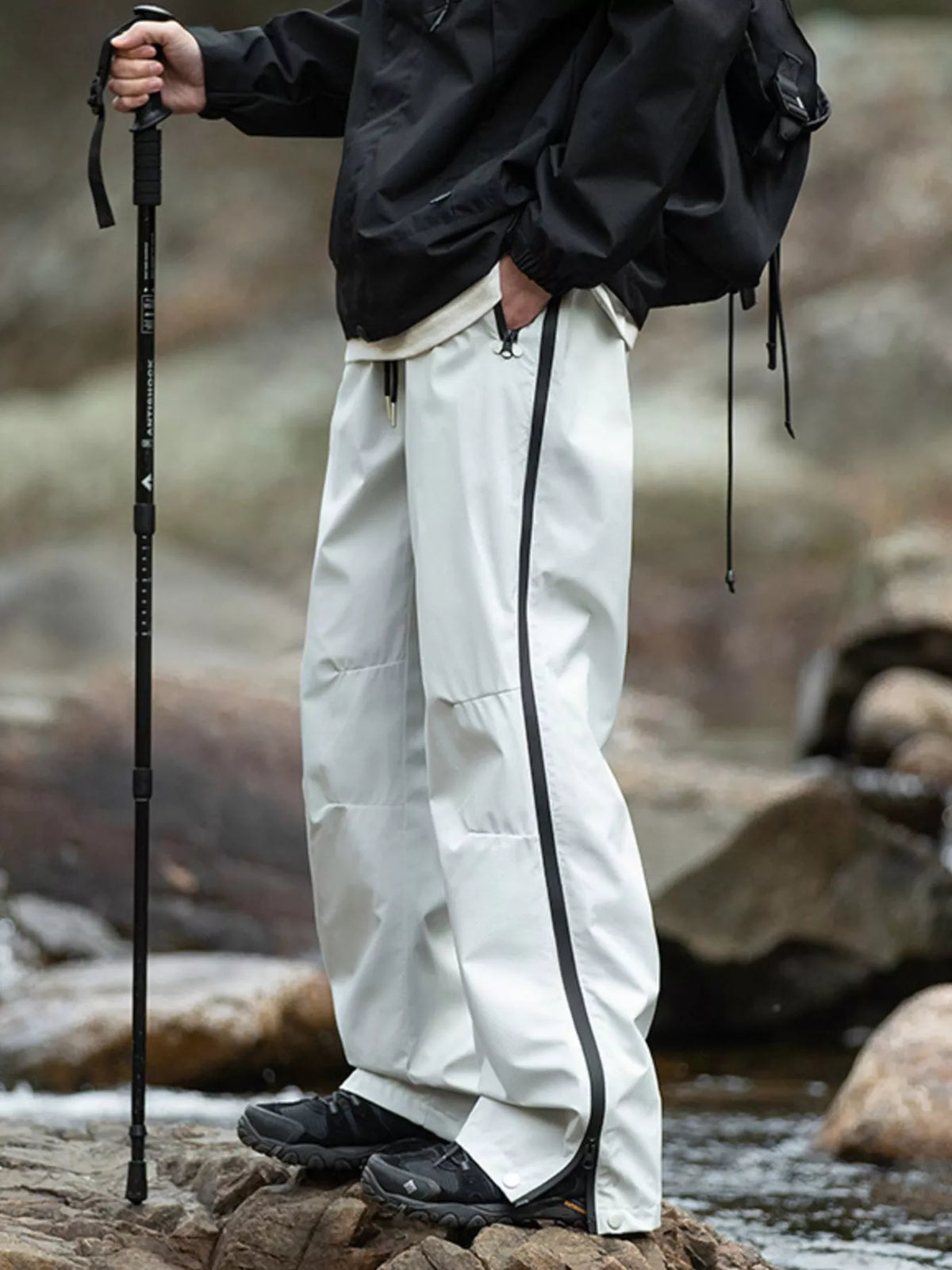 Men's light gray tactical cargo pants with multiple pockets and a drawstring waist.