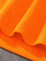 Close view of the stitched hem and smooth orange fabric on the children's dinosaur T-shirt