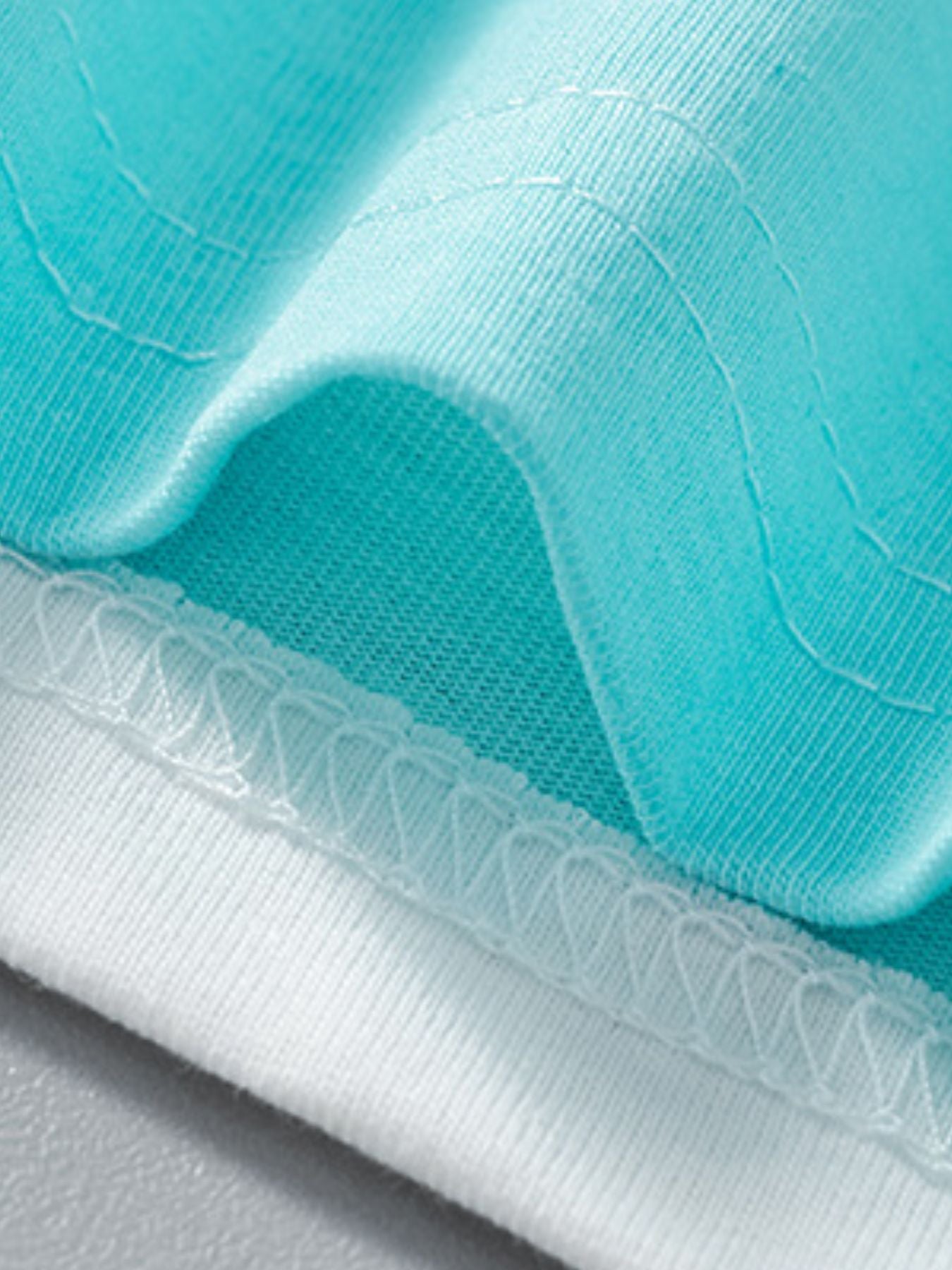 Close view of the turquoise and white hem stitching on the children's animal print t-shirt