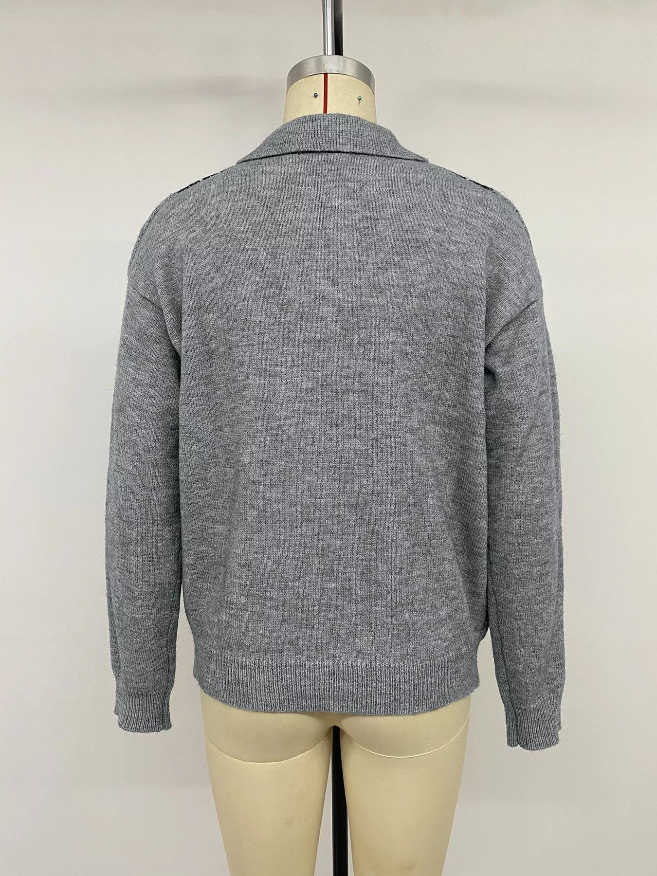 Back view of a plain gray long sleeve polo sweater on a mannequin