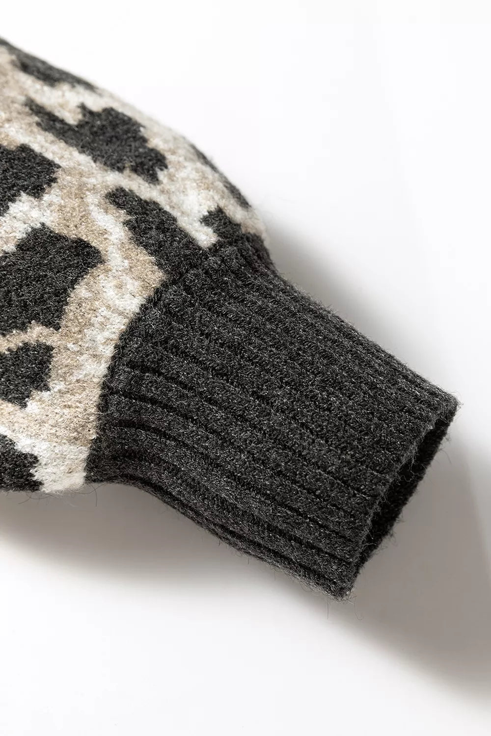 Close up detail of the ribbed cuff on the gray and black leopard print baggy sweater.