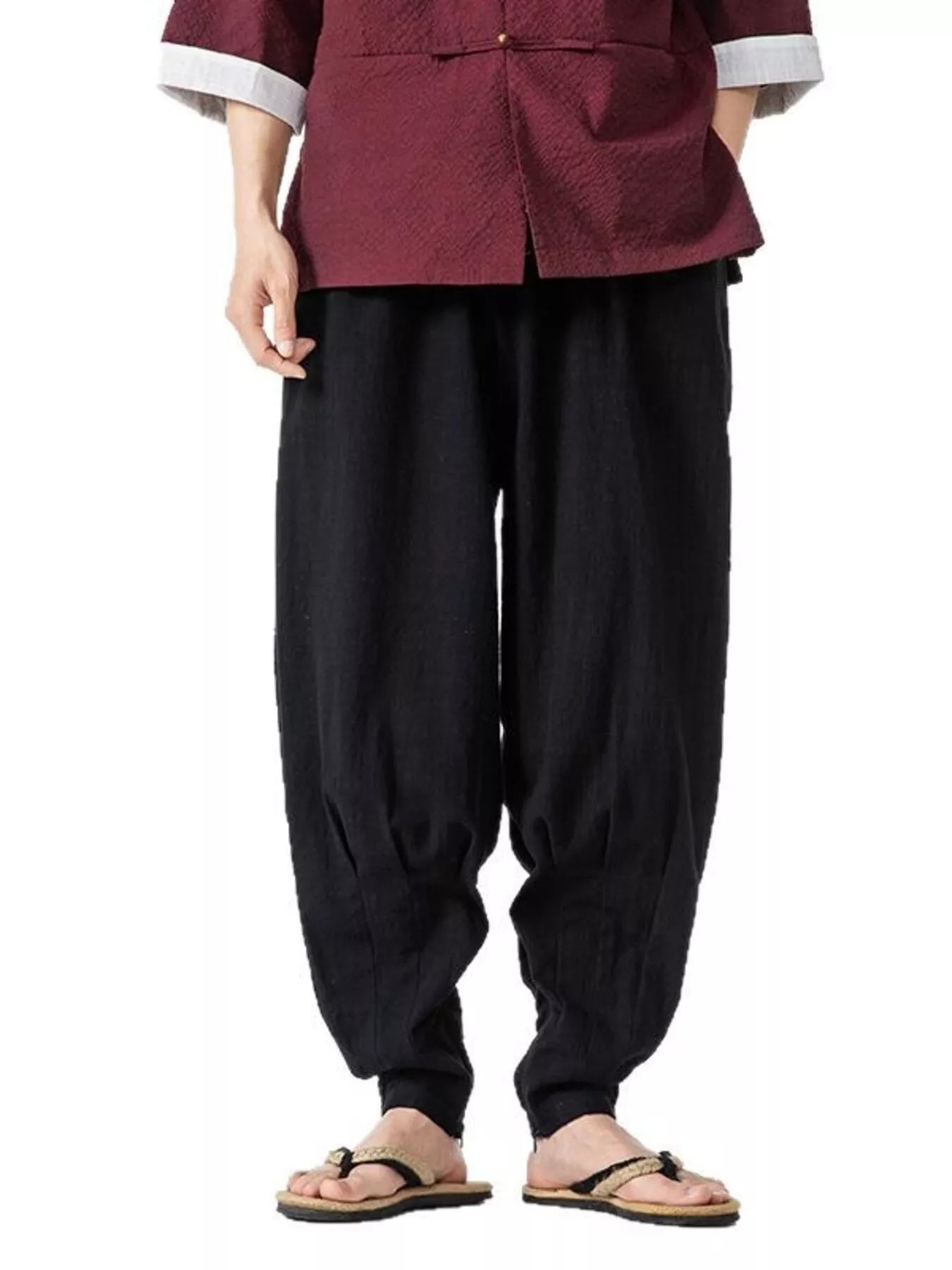 Men's black loose-fit harem pants with pockets and lightweight fabric.