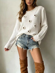 Front view of a white textured knit sweater with white floral appliques and long sleeves