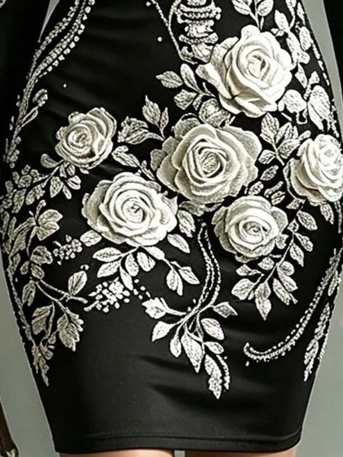 Close detail of white rose print on black long sleeve bodycon dress skirt