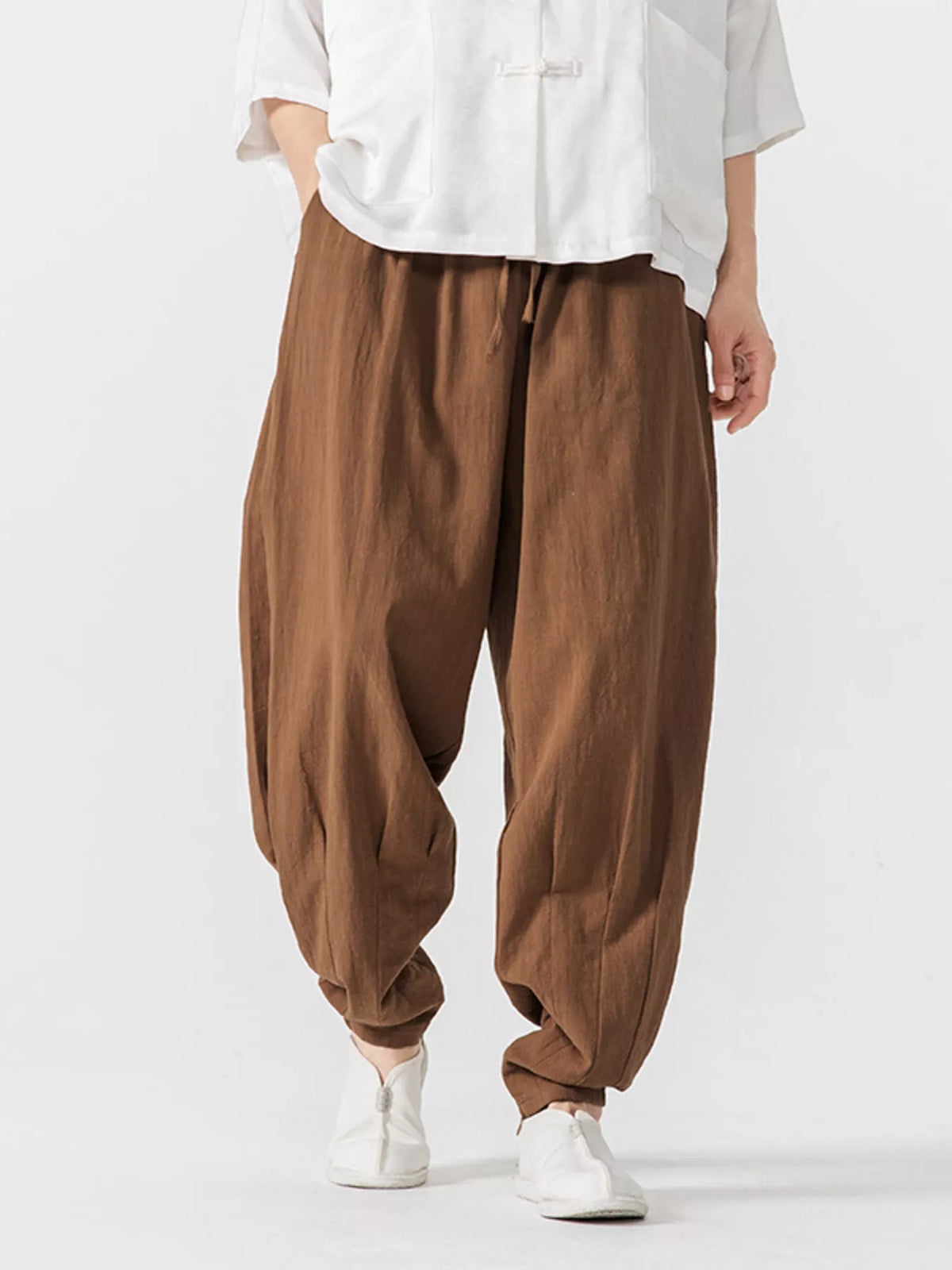 Men's caramel loose-fit harem pants with pockets and lightweight fabric.