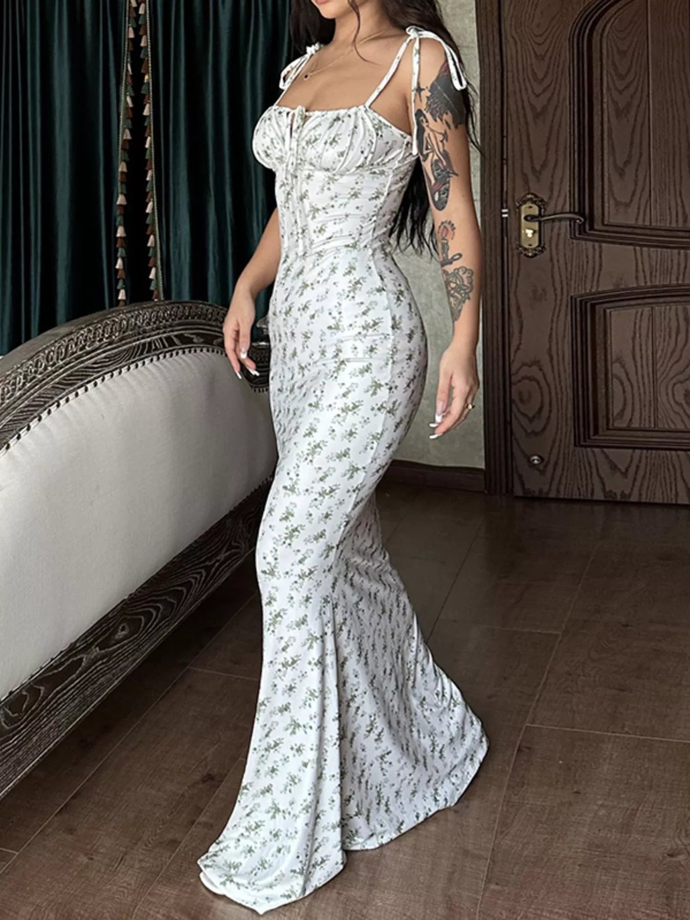 Side view of model wearing white floral print bodycon maxi dress with tie straps and flared hem
