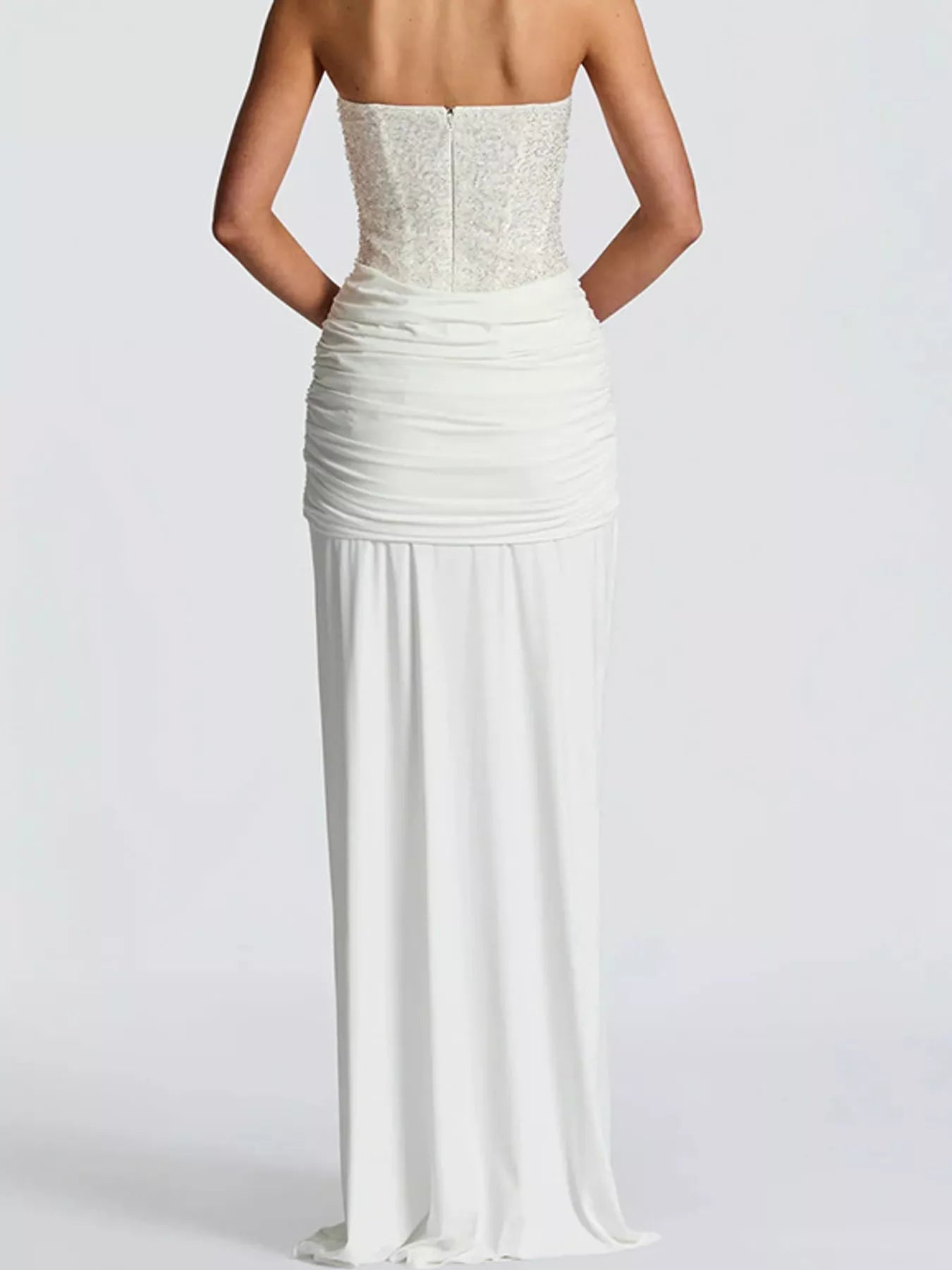 White strapless sequin corset maxi dress on model, full length back view showing zip