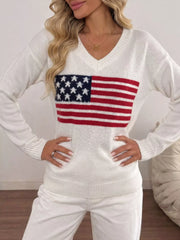 Front view of white V neck knit sweater with American flag print and hands on hips.