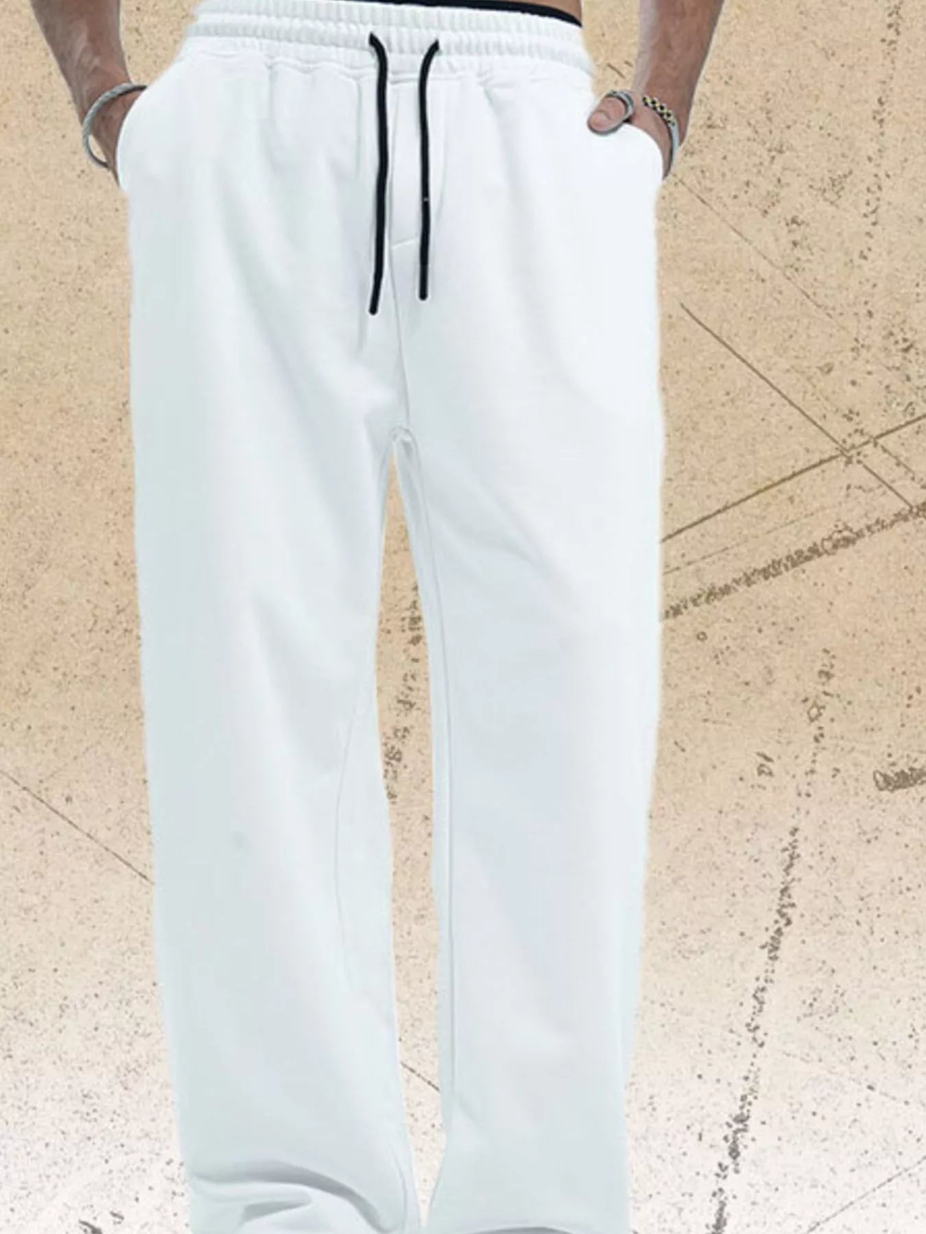 Men's white wide-leg pants with a drawstring waist.