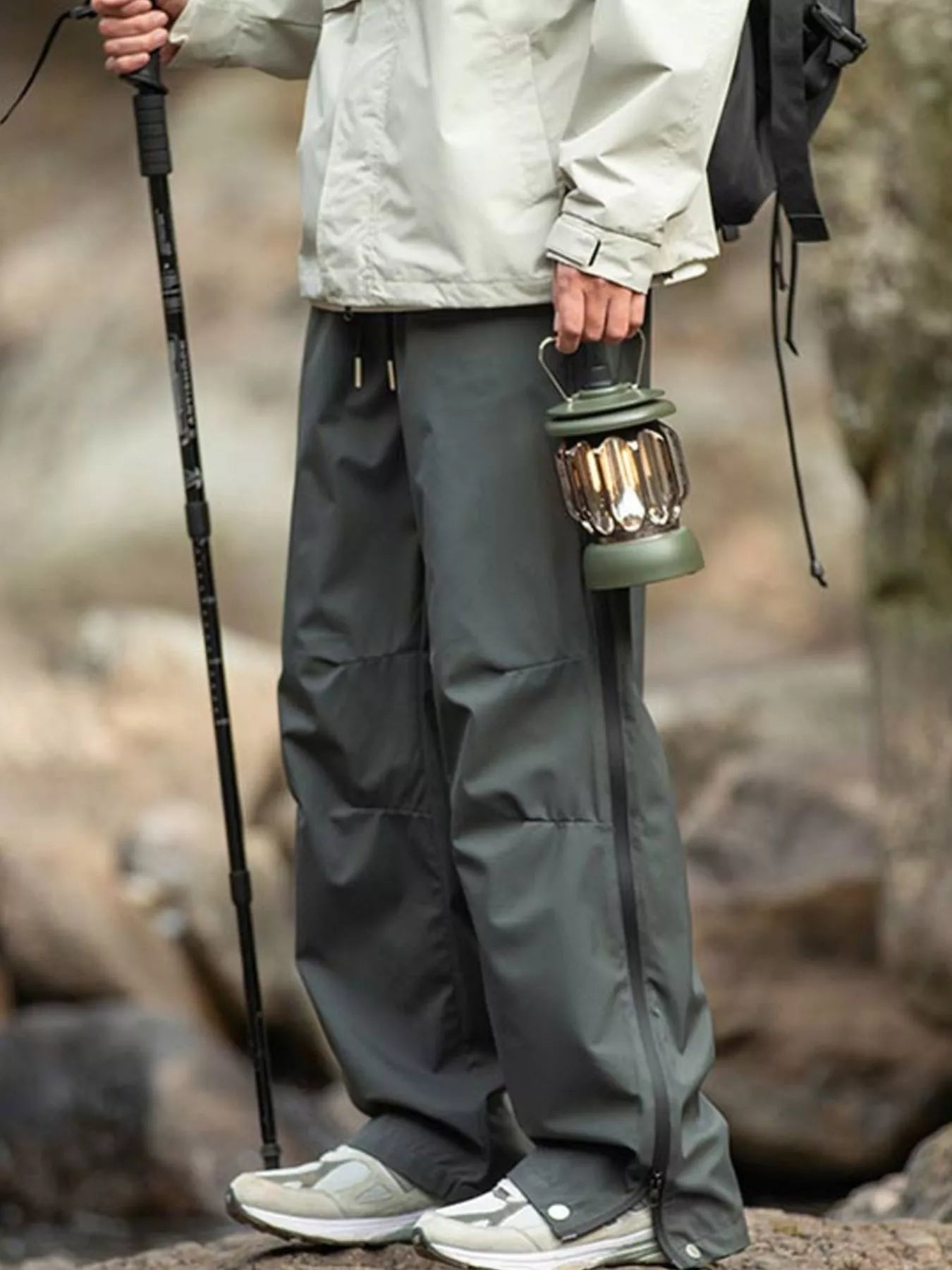 Men's dark gray tactical cargo pants with multiple pockets and a drawstring waist.