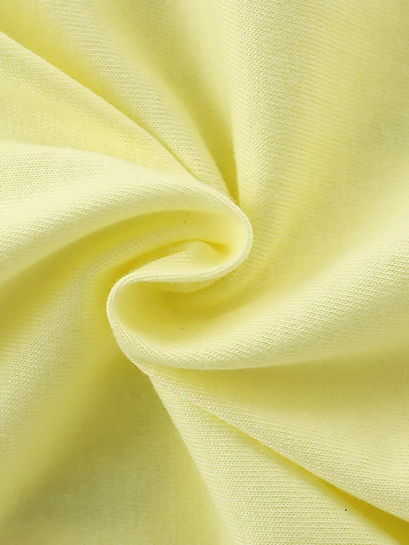 Close view of the light yellow children's tee fabric gathered in a soft swirl showing knit texture