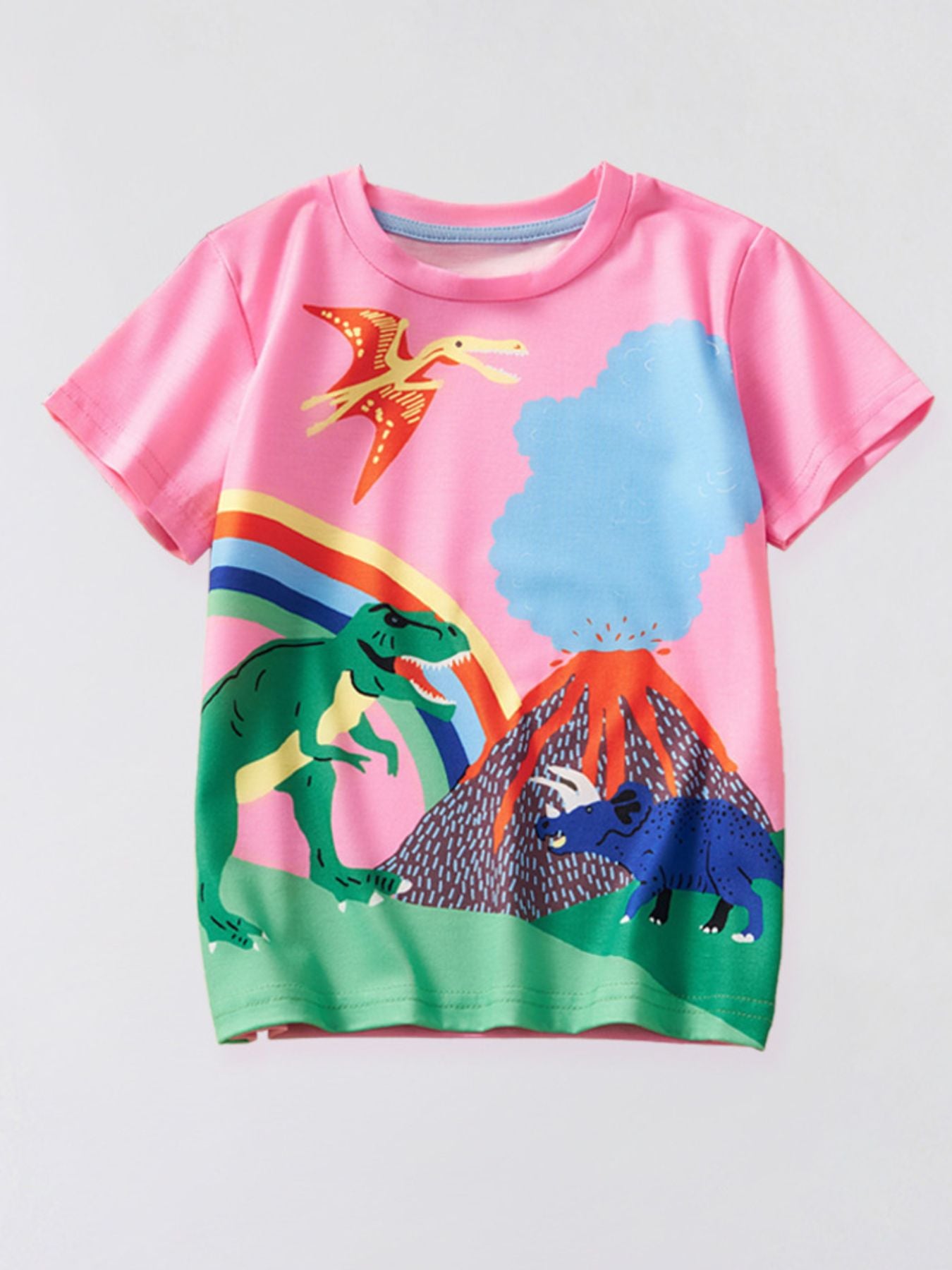 Front view of a blush pink children's t-shirt with dinosaurs, a volcano, and a rainbow