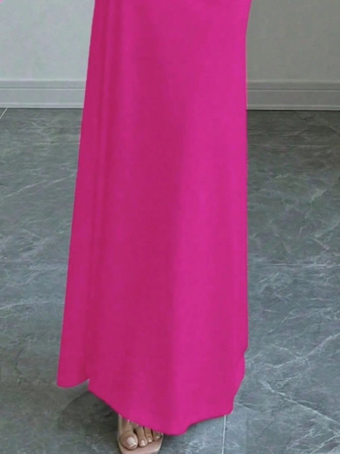 Close view of vivid pink off shoulder maxi skirt hem and floor length fabric