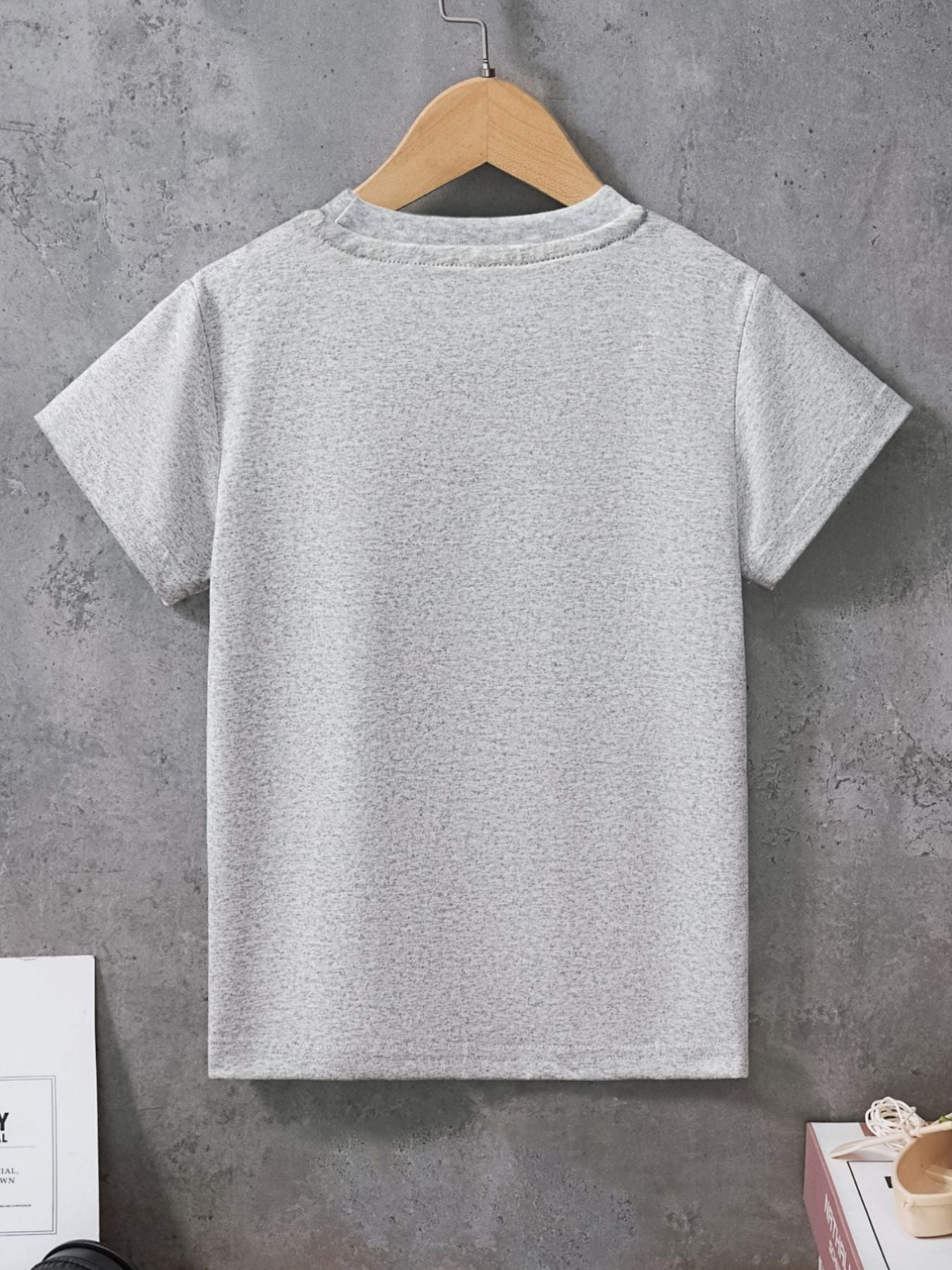 Plain back view of a light gray children's crew neck short sleeve T-shirt hanging on a hanger
