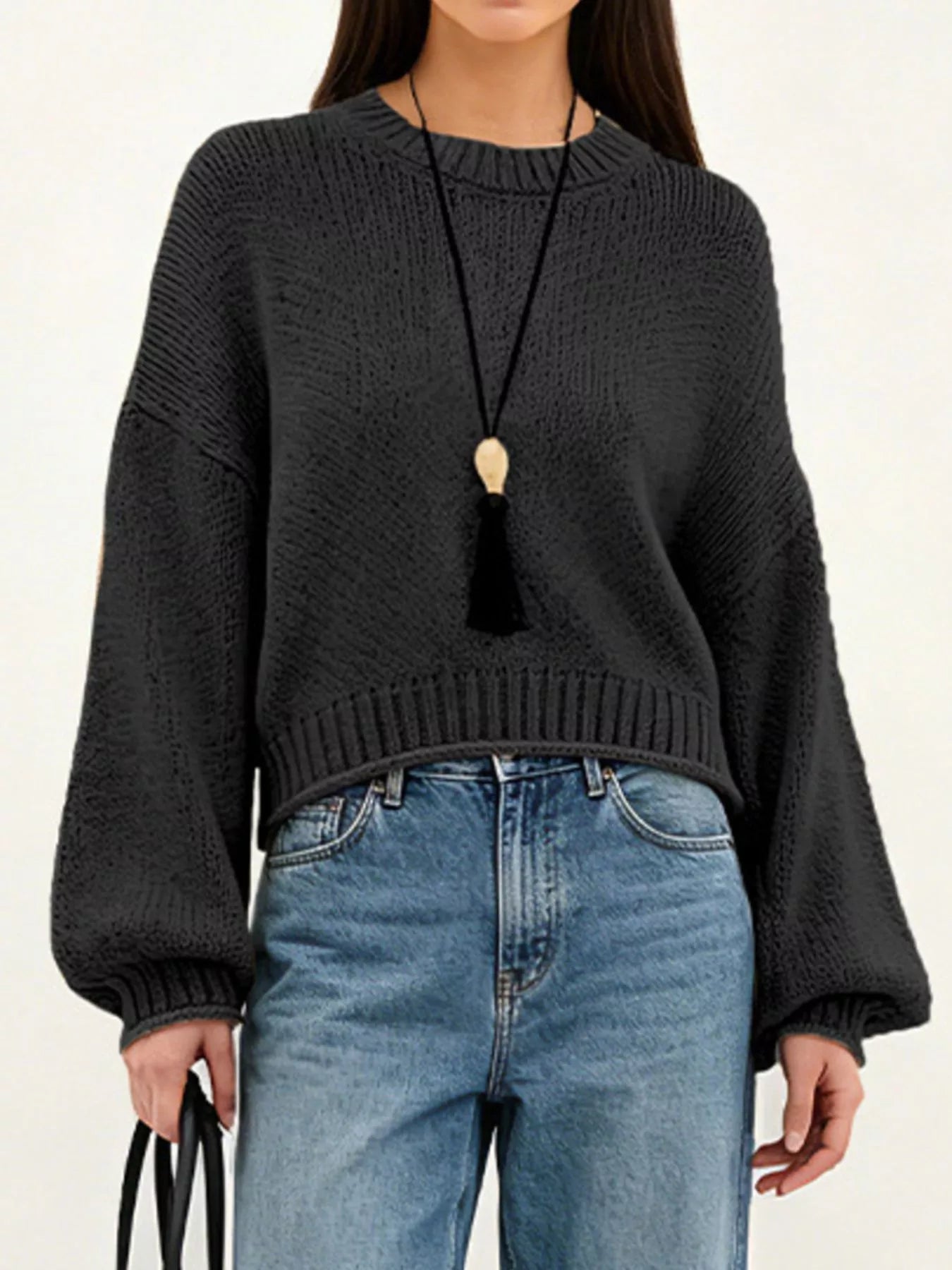 On-model front view of a black oversized chunky knit sweater with balloon sleeves