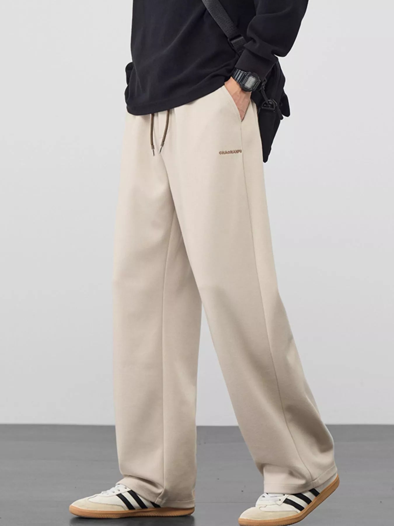 Men's khaki loose fit casual pants with a drawstring waist and pockets.