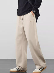 Men's khaki loose fit casual pants with a drawstring waist and pockets.