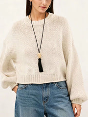 Close on-model front view of a cream oversized chunky knit sweater with ribbed hem