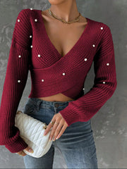 Burgundy crisscross front sweater with pearl details worn over jeans