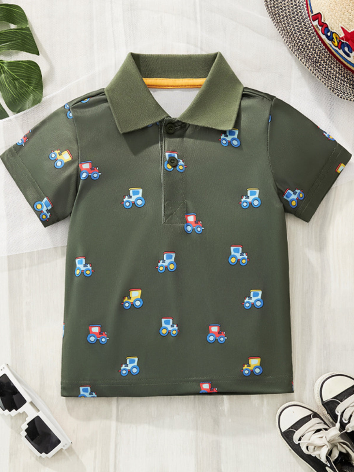Flat lay front view of army green children's polo shirt with small colourful tractor prints