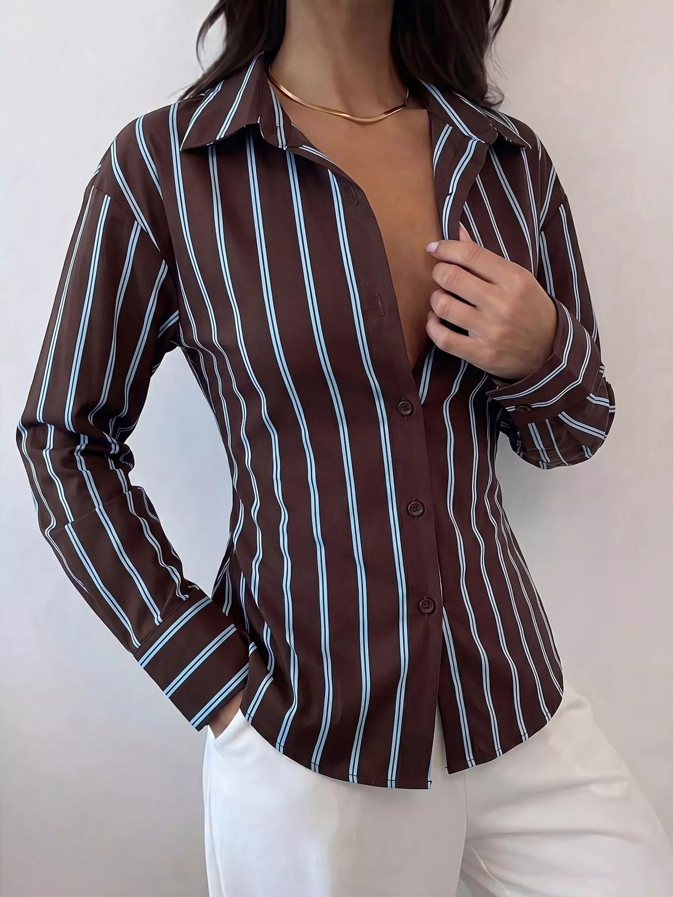 Close front view of chocolate striped button down shirt with collar and white trousers