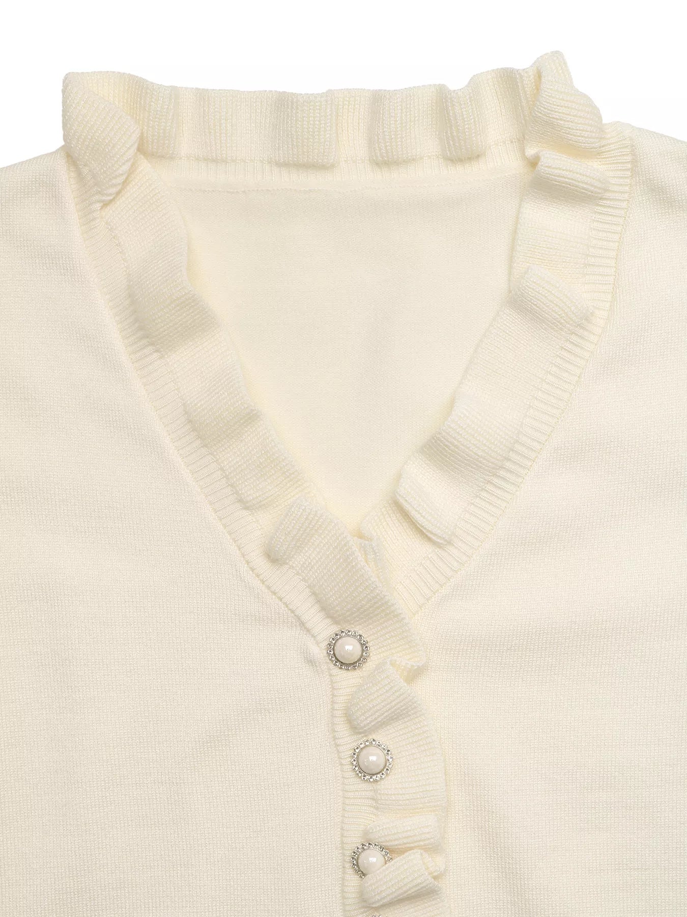 Close up flat lay of cream V neck knit top showing ruffle trim and pearl buttons