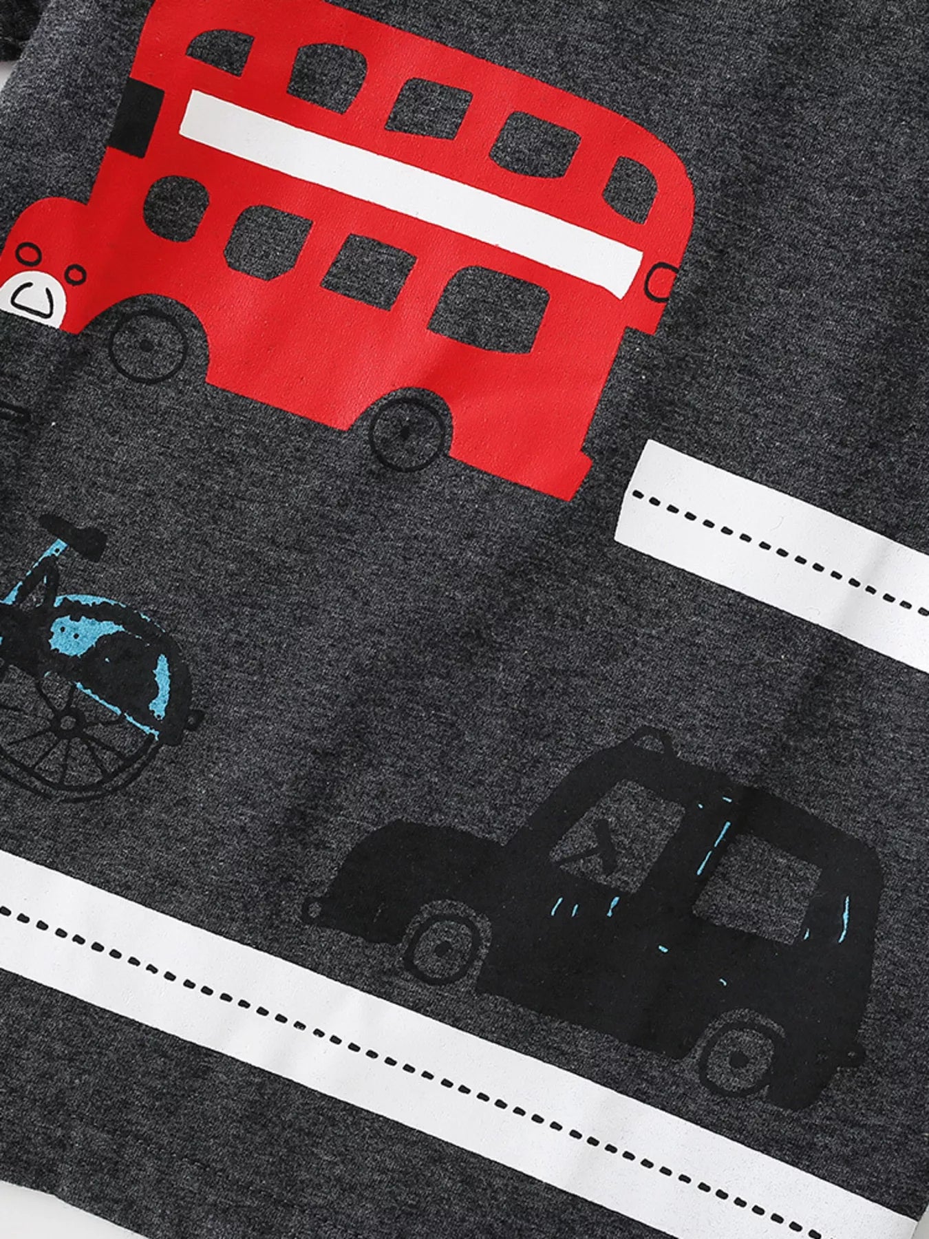 Close up detail of red double decker bus and black car prints on dark gray children's t-shirt