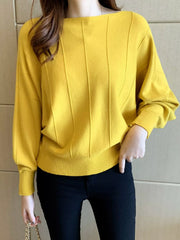 Front view of a yellow batwing sleeve knit top with vertical seams and ribbed hem.