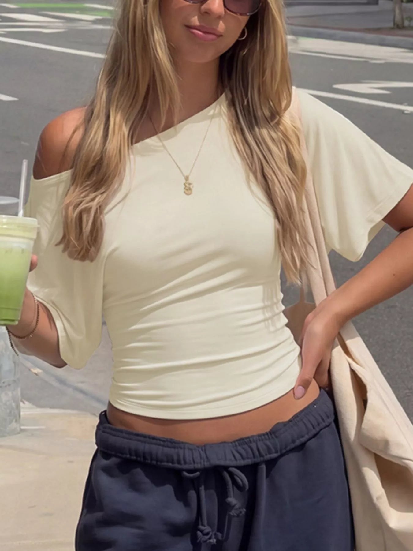 Cream boat-neck short-sleeve T-shirt shown on a model in a lifestyle street setting